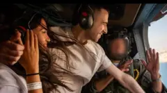 Casal dentro de helicóptero no ar sorrindo