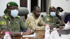 Assimi Goita au milieu de deux autres militaires en tenue
