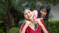 ਮਾਂ ਧੀ ਮੀਂਹ ਵਿੱਚ ਖੁਸ਼ ਹੁੰਦੀਆਂ ਹੋਈਆਂ