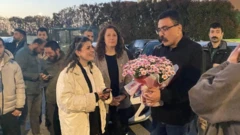 Avukat Selçuk Kozağaçlı'yı Silivri'deki cezaevi çıkışında tanıyanlar, tahliye olacak arkadaşları için hazırladıkları çiçeği veriyor.