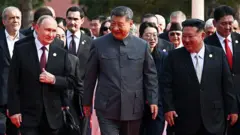 সামরিক কুচকাওয়াজের আগে চীনের প্রেসিডেন্ট শি জিনপিং, রাশিয়ার প্রেসিডেন্ট ভ্লাদিমির পুতিন এবং উত্তর কোরিয়ার নেতা কিম জং উনসহ বিভিন্ন দেশের অতিথিদের একসাথে হেঁটে এগিয়ে আসতে দেখা যায়