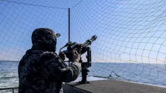 Ukrayna Donanması'na ait bir devriye botunun mürettebatından bir kişi, 7 Mart 2026'da Ukrayna'nın Karadeniz sularında gerçekleştirilen bir devriye görevi sırasında makineli tüfeğin başında duruyor.