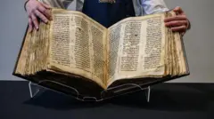 Littafin Injila mai tsarki a hannun wani ma'aikacin gidan tarihi. 