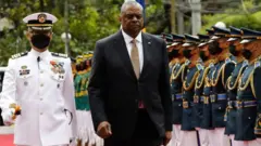 Le secrétaire américain à la Défense, Lloyd Austin, passe en revue une formation de soldats.