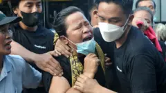 Ibu almarhum Brigadir Nofriansyah Yosua Hutabarat atau Brigadir J, Rosti Simanjuntak (tengah) didampingi kerabatnya histeris saat mendatangi makam anaknya sebelum pelaksanaan autopsi ulang di Sungai Bahar, Muarojambi, Jambi.