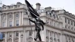 مجسمه ای که امضای بنکسی زیر آن نوشته شده است