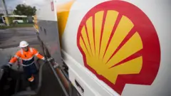 The Shell logo on a new fuel tanker truck as it delivers petrol to a gas station