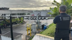 Agente da polícia federal observa do alto de um barraco refinaria de combustível