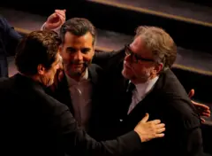 Benício del Toro, Wagner Moura e Guillermo del Toro se confraternizam na cerimônia do Oscar