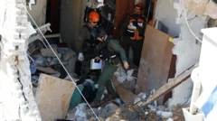 Tres soldados vestidos de verde y con cascos caminan por los escombros de un edificio
