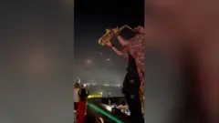 Saksofonista nastavlja sa svirkom rakete osvetljavaju nebo