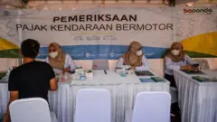 Petugas melayani warga yang akan membayar pajak kendaraan saat operasi pemeriksaan pajak kendaraan bermotor di Jalan Diponegoro, Bandung, Jawa Barat, Rabu (13/11/2024).