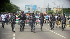 Policemen waka for front of protesters as members of civil society groups and di Nigeria Labour Congress do collabo for peaceful protest for Ikeja, Lagos, Nigeria, on December 17, 2025, sake of how insecurity be for di kontri.