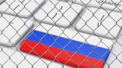 یک کیبورد که روی یکی از کلیدها پرچم روسیه است، نزدیک به کلید حدف، کل کیبورد پشت یک حصار سیمی است