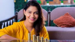 ஒரு பெண் நாணயங்கள் முன் அமர்ந்திருக்கிறார் 