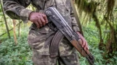 Ọkunrin kan to wọ aṣọ ologun gbe ibọn lọwọ
