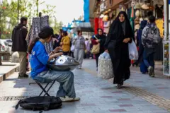 Mujer camina por un mercado en Teherán