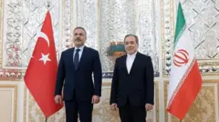 وزرای خارجه ایران و ترکیه در کنار هم ایستاده و در حال گرفتن عکس