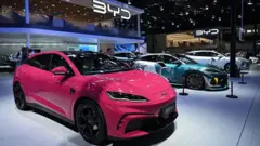 BYD汽車展銷現場，三台分別為玫紅色、螢光綠、銀白色的車並列。