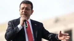 اکرم امام‌اوغلو، میکروفون به دست در حال سخنرانی