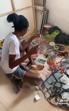 Patience Adekunle wọ sokoto penpe ati asọ T-Shirt, o tẹri mọlẹ n to waya to fẹ fi ya aworan