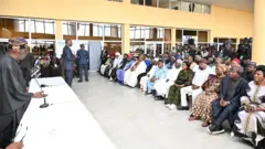 Aaẹ Bola Tinubu duro niwaju ọpọ ero ninu gbọngan nla kan nilu naa, o n bawọn eeyan to joko sọrọ