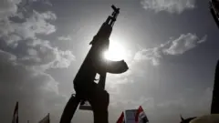صورة يظهر فيها سلاح مرفوعاً بيد بين حشود والشمس تظهر وكأنها بجانب السلاح.