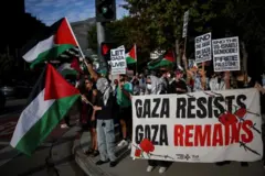 লস অ্যাঞ্জেলেসে ইসরায়েলের কনস্যুলেট জেনারেলের অফিসের বাইরে ফিলিস্তিনের পকাতা হাতে নিয়ে বিক্ষোভ, একটি ব্যানারে লেখা- প্রতিরোধ গড়ে তুলবে গাজা 