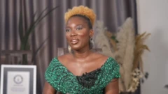 A lady on green wit yellow hair sitting down