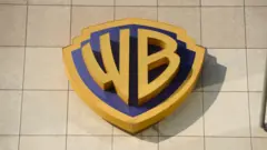 Вывеска Warner Bros (Discovery) на фотографии в штаб-квартире телекомпании TVN в Варшаве, Польша, 6 августа 2024 года.