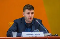 Juan Cuatrecasas Cuevas sentado, em pronunciamento público