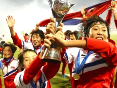 북한 축구 선수들이 트로피를 들고 환호하고 있다