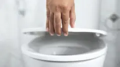Унітаз і чоловіча рука