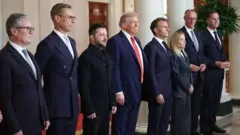 18 СЕРПНЯ: Президент США Дональд Трамп та президент України Володимир Зеленський позують для фото з європейськими лідерами після зустрічі в Овальному кабінеті Білого дому 18 серпня 2025 року у Вашингтоні, округ Колумбія. Зліва направо: прем'єр-міністр Великої Британії Кір Стармер, президент Фінляндії Александр Стубб, президент України Володимир Зеленський, президент США Дональд Трамп, президент Франції Еммануель Макрон, прем'єр-міністр Італії Джорджія Мелоні, канцлер Німеччини Фрідріх Мерц та Генеральний секретар НАТО Марк Рютте. Президент Трамп приймав президента Зеленського в Білому домі для двосторонньої зустрічі, а пізніше розширеної зустрічі з європейськими лідерами для обговорення мирної угоди між Росією та Україною.