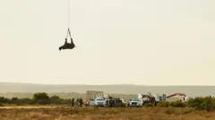 Badak terbang di helikopter dengan diikat kakinya.