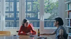 Marina Freixa (à direita) e a mãe, Mariona, sentadas à mesa, com um grande vão de janela ao fundo.