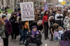 Persona portando una pancarta con el lema "100 años, 100% feministas".