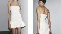 Uma modelo de cabelos castanhos posa em um vestido curto branco com babados, com sombras aparecendo para fazer com que suas pernas pareçam mais finas