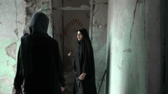 Amaineh Nademi camina por uno de los pasillos que aún se conservan de la escuela primaria Shajareh Tayyebeh en Minab. Viste un chador negro y le muestra a Nawal al Maghafi, reportera de la BBC, los daños en la escuela. Las paredes de hormigón están agrietadas y anteriormente habían sido pintadas de verde pastel.