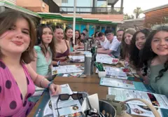 Un grupo de jóvenes sentados en una mesa en un restaurante en un país extranjero.