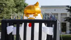 Escultura inflável de um frango dentro de uma cela, representando Donald Trump, criada pelo artista Taran Brar, é exibida na Place des Nations, em frente à sede europeia das Nações Unidas, em Genebra, Suíça, em 25 de julho de 2025.