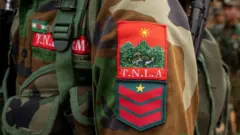  TNLA တပ်ဖွဲ့ဝင်တစ်ဦးကို ယူနီဖောင်းတံဆိပ်နဲ့ မြင်တွေ့ရတာဖြစ်ပါတယ် 