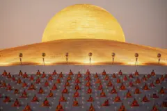 Imagem panorâmica onde se vê um grupo de monges rezando.