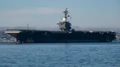 USS Abraham Lincoln Aralık 2024'te San Diego'ya yaklaşırken yüzlerce denizci güvertede yan yana durmuş 