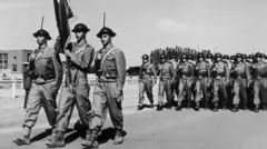 جنود مشاة أتراك يحملون راية فوجهم خلال عرض عسكري في أنقرة عام 1952 