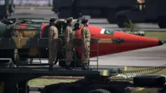 پاکستانی فوجی اسلام آباد میں جوہری وار ہیڈ لے جانے کی صلاحیت رکھنے والے میزائل کی نمائش کرتے ہوئے