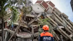 Rescatista ante los escombros de un edificio en La Guaira