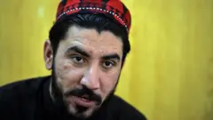 منظور پښتین چې خپله ځانګړې خولۍ یې پر سر ده، د خبرو پرمهال ښکاري.