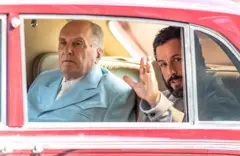 Adam Sandler e Robert Duvall durante a gravação de um filme. Eles estão dentro de um carro