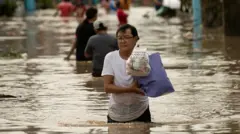 ช﻿าวฟิลิปปินส์เดินฝ่าน้ำท่วมสูงถึงเอว